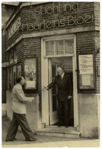 Het gebouwtje van 'Stichting Haarlems Bloei' aan het Stationsplein. Op de foto C.S.Th. van Gink verwelkomd zijn opvolger W. v. Willige. NL-HlmNHA 54014829
