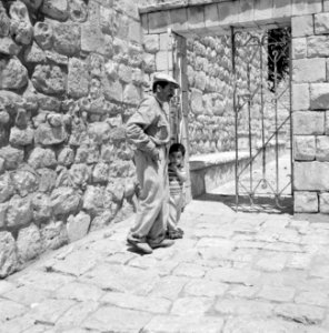 Het dorp Peki'in in Opper Galilea. Man met jongentje bij een poort met een trali, Bestanddeelnr 255-3764