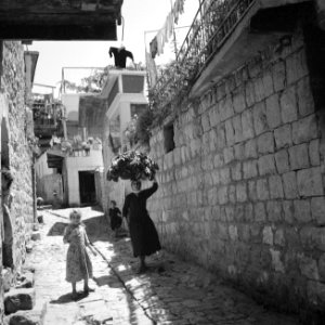 Het dorp Peki'in in Opper Galilea. Vrouw met een mand op het hoofd en twee jonge, Bestanddeelnr 255-3755 photo