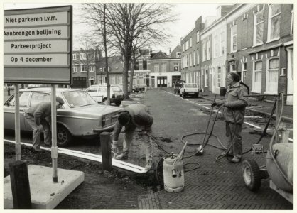 Het aanbrengen van parkeervakken voor een parkeerexperiment waarbij bewoners van de Vijfhoek, Raaks en Doelen voor vijf gulden per maand een vignet kunnen kopen. Het experiment is ook bedoel, NL-HlmNHA 54031826