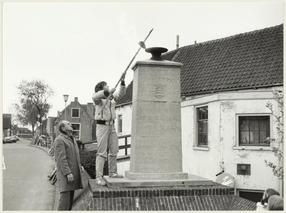 Het eeuwige vuur bij het verzetsmonument aan het Kerkplein wordt ontstoken door een estafette loper uit Haarlem. NL-HlmNHA 54012277
