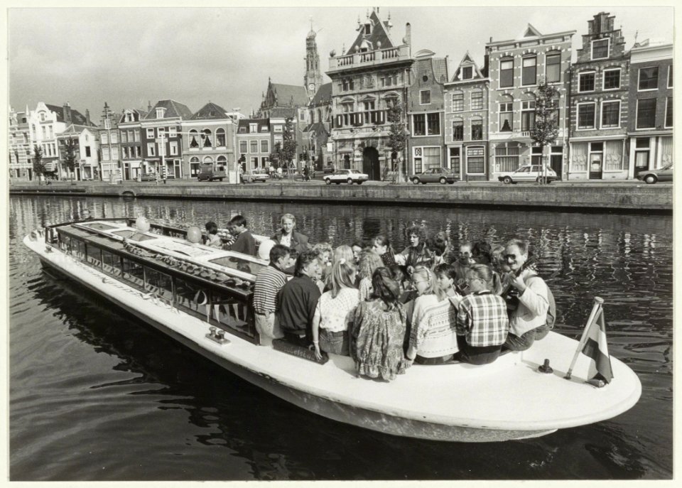Het jeugdkoor Onwijs vaart per rondvaartboot door het Spaarne i.v.m. het 50-jarig bestaan van het Anjerfonds. NL-HlmNHA 54031476
