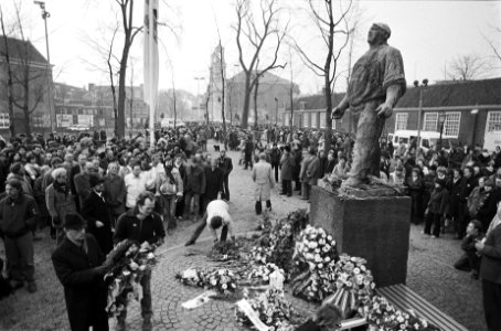 Herdenking van de Februaristaking bij de Dokwerker in Amsterdam. Mensen leggen b, Bestanddeelnr 932-0060