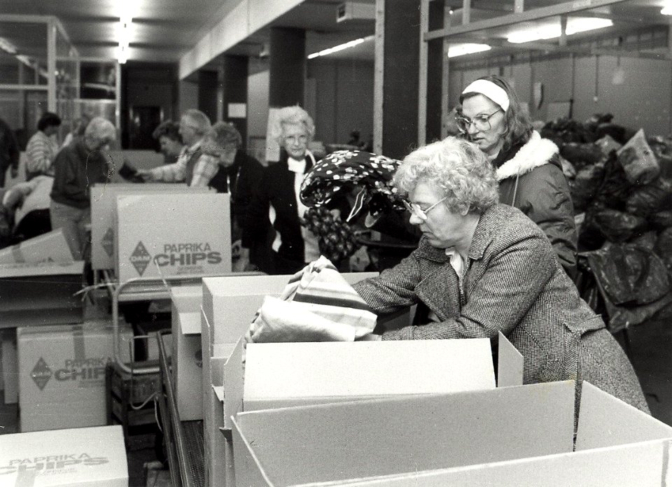 Het inpakken in dozen van kleding voor Polen in het postkantoor aan de Baljuwslaan te Haarlem afbeelding door C.de Boer. - 1982. - 1 foto zwart-wit 16,8x23,1 cm. Afgebeeld is het inpakken va, NL-HlmNHA 54010752