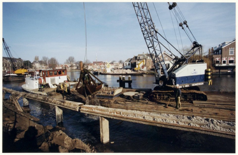 Herstelwerkzaamheden aan de walkant van het Spaarne aan de Koudenhorn. Aan de overkant worddt de werf Zuidam gesloopt. NL-HlmNHA 54036926