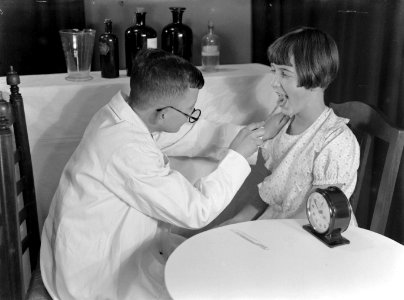 Herman speelt een dokter die bij Willy in de keel kijkt, Bestanddeelnr 189-1156