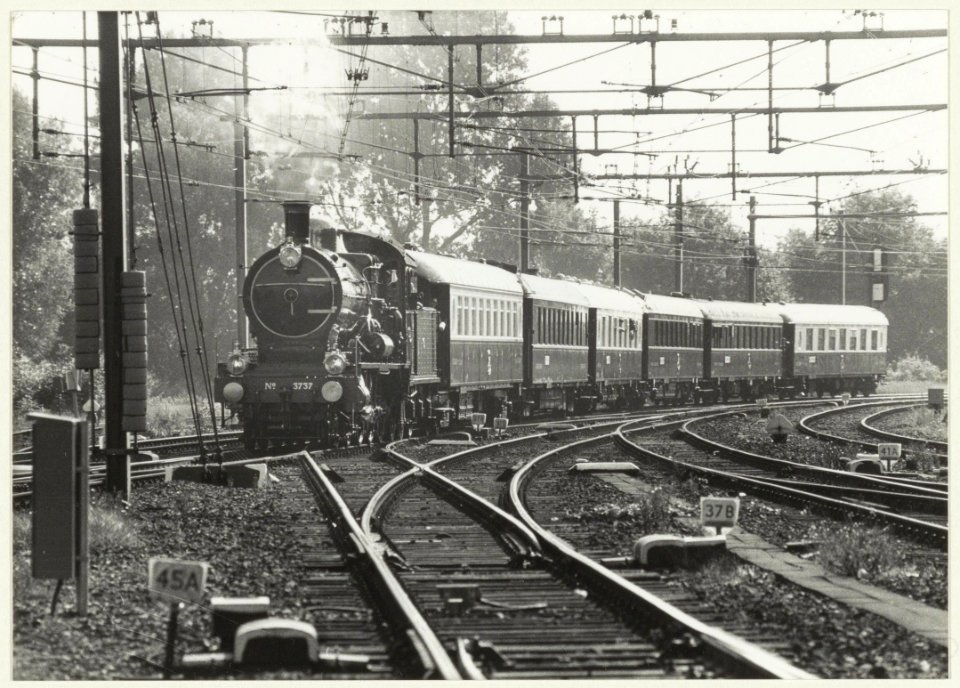 Historische trein in het kader van NS 150, getrokken door Loc 3737 en CIWL rijtuigen met genodigden en pers loopt binnen op spoor 6 in Haarlem. De rit ging van Amsterdam via Haarlem, Leiden , NL-HlmNHA 54023480