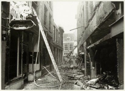 Het nablussen van de brand in de Paarlaarsteeg, bij de Koningstraat. Het pand met het lantaarntje en het ronde uithangbord was café Piet in de Ton. NL-HlmNHA 54003418