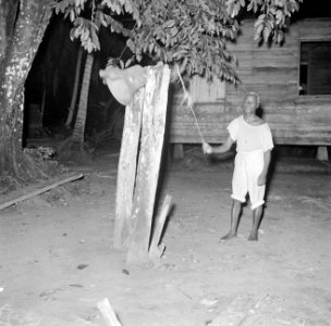 Het luiden van de klok voor de kerkdienst in Langetabberje in Suriname, Bestanddeelnr 252-6729
