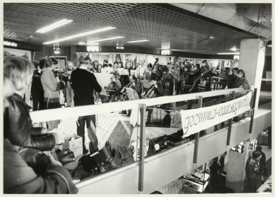 Het Noord-Hollands Philharmonisch Orkest aan het slot van zijn muzikale actiedag (wegend bezuinigingen) in de Brinkmann-passage. NL-HlmNHA 54013097