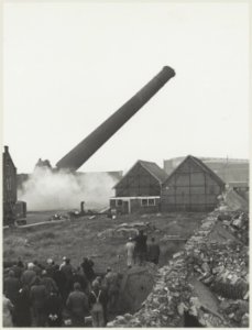 Het opblazen van de oude schoorsteen van de gasfabriek op het terrein aan de Harmenjansweg. NL-HlmNHA 54011883