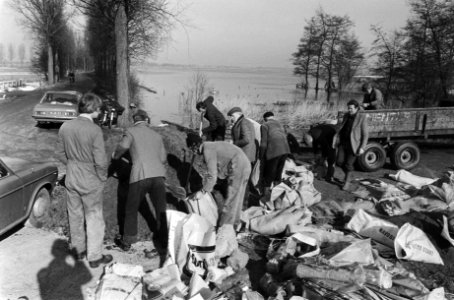 Het vullen van zandzakken door hulpverleners, Bestanddeelnr 930-1530