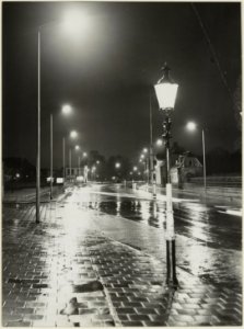 Het schijnsel van fonkelende lantaarns bij avond reflecteert op het beregende Soendaplein, ziende naar het zuiden. NL-HlmNHA 54004425
