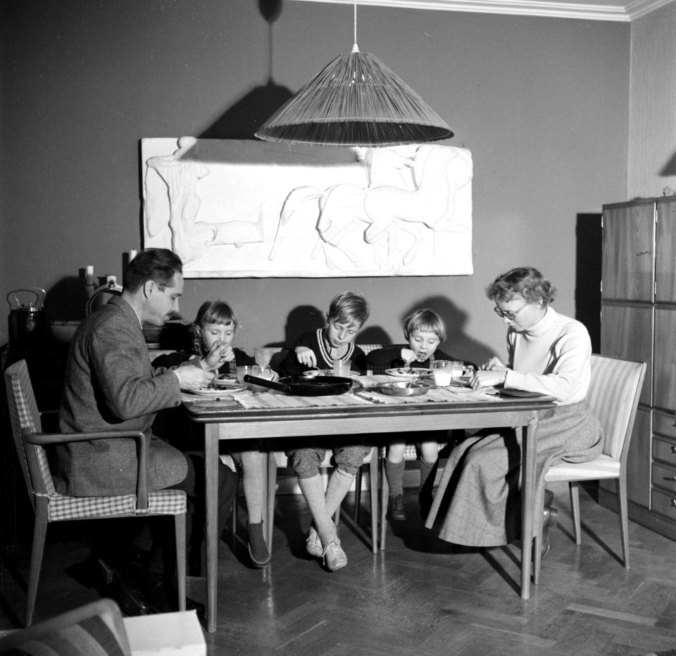 Het gezin zittend aan de eettafel met de avondmaaltijd, Bestanddeelnr 252-8766