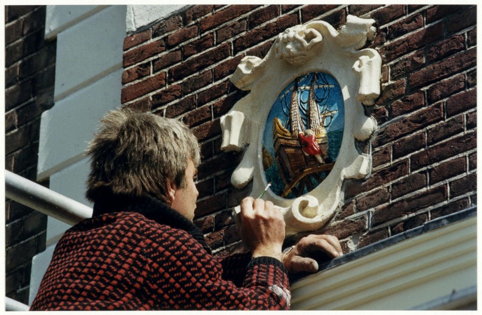 Het polychromeren van een gevelsteen in het pand Spaarne 35, hoek Hoogstraat. NL-HlmNHA 54037313