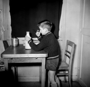 Het zoontje van de conciërge maakt een melkfles open, Bestanddeelnr 252-9323