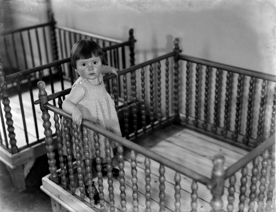 Het meisje Greetje in het Tehuis Annette staat in de box, Bestanddeelnr 252-0395