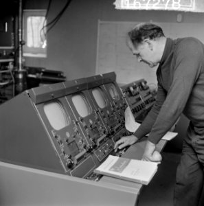 Het REM-eiland, technicus Maxwell Thompson bij een tv-monitor, Bestanddeelnr 916-7278