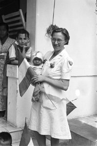 Het Prinses Margriet Hospitaal. Verpleegster en baby. Jongen kijkt toe, Bestanddeelnr 151-6-3