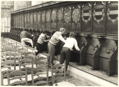 Het reinigen van de koorbanken voor de officiële opening van de Grote Kerk na de restauratie. NL-HlmNHA 54025680