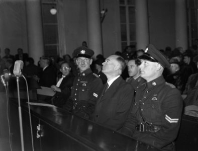 Het proces van Mussert. Mussert, in de beklaagdenbank, luistert naar de aanklach, Bestanddeelnr 901-1479
