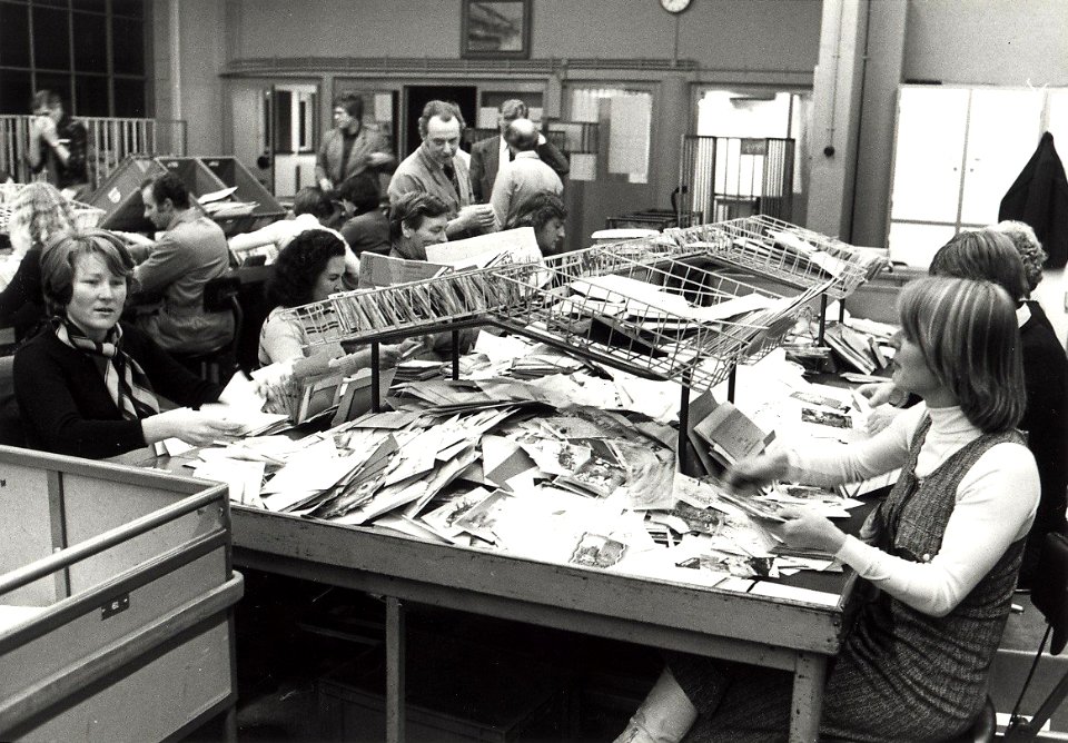 Het sorteren van kerst- en nieuwjaarspost in het postkantoor aan de Baljuwslaan te Haarlem afbeelding door C.de Boer. - 1976. - 1 foto zwart-wit 11,9x17 cm. Afgebeeld is het sorteren van de , NL-HlmNHA 54010752