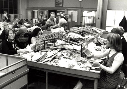 Het sorteren van kerst- en nieuwjaarspost in het postkantoor aan de Baljuwslaan te Haarlem afbeelding door C.de Boer. - 1976. - 1 foto zwart-wit 11,9x17 cm. Afgebeeld is het sorteren van de , NL-HlmNHA 54010752