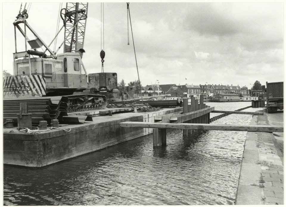 Het slaan van een damwand in het Spaarne. NL-HlmNHA 54016839