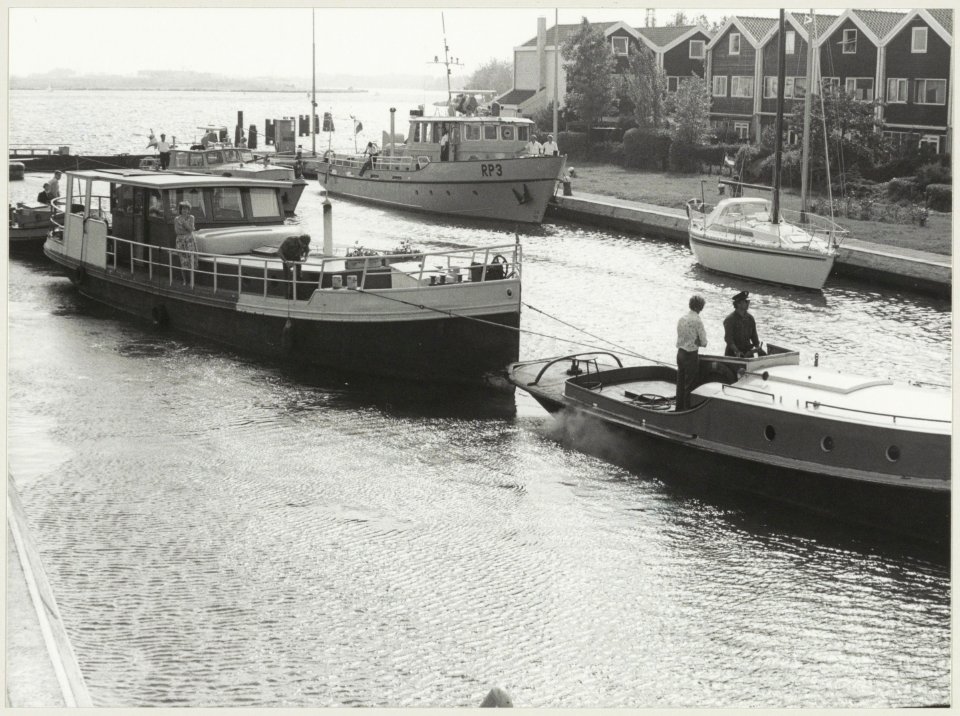 Het verslepen van het illegale woonschip ' de Nieuwe Gracht' van de familie J. Klooster uit Haarlem naar het zijkanaal B. Foto de schepen in de Grote Sluis in Spaarndam. NL-HlmNHA 54012285
