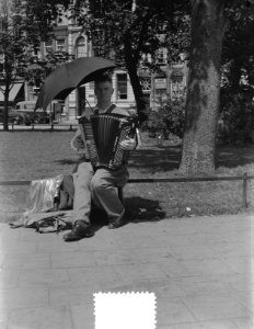 Harmonikaspeler van Frederiksplein heeft het warm met paraplu, Bestanddeelnr 905-8105
