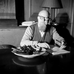 Hans Peter Sørensen aan een tafel met daarop een asbak vol met pijpen, vermoedel, Bestanddeelnr 252-9005 photo