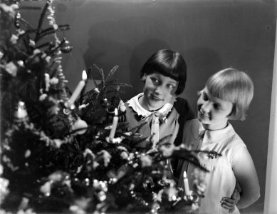 Hans en Renée (stiefdochters van Van de Poll) kijken naar een versierde Kerstboo, Bestanddeelnr 252-0956
