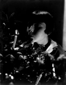 Hans (stiefdochter van Van de Poll) blaast kaars uit in een Kerstboom, Bestanddeelnr 252-0962