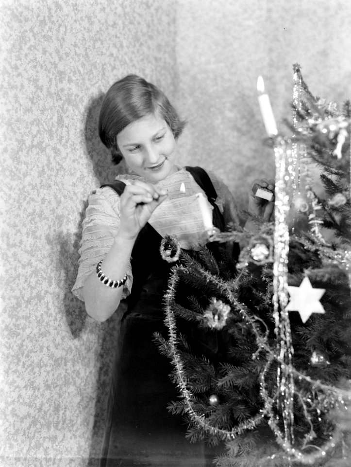 Hans steekt de kaarsjes aan in de versierde kerstboom, Bestanddeelnr 189-1126