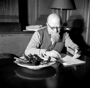 Hans Peter Sørensen aan een tafel met daarop een asbak vol met pijpen, vermoedel, Bestanddeelnr 252-9007 photo
