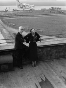 Harry Laponder met een onbekende vrouw op het terras van het luchthavengebouw me, Bestanddeelnr 190-1351