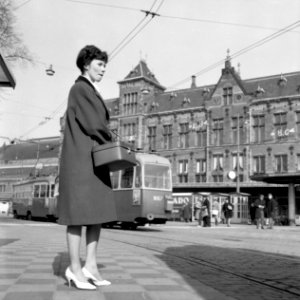 HUA-150060-Afbeelding van een wachtende reizigster en een tram op het Stationsplein voor het N.S-station Amsterdam C.S. te Amsterdam photo