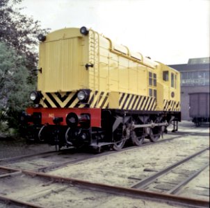 HUA-151543-Afbeelding van de diesel electrische rangeerlocomotief nr 633 serie 600 van de NS in gele uitvoering en met schrikstrepen bij de hoofdwerkplaats van d