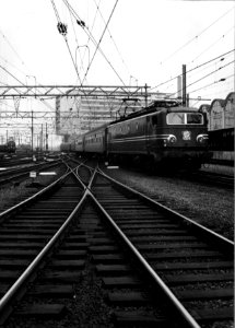 HUA-151565-Afbeelding van een trein getrokken door de electrische locomotief nr. 1304 (serie 1300) van de N.S. op het emplacement te Amsterdam