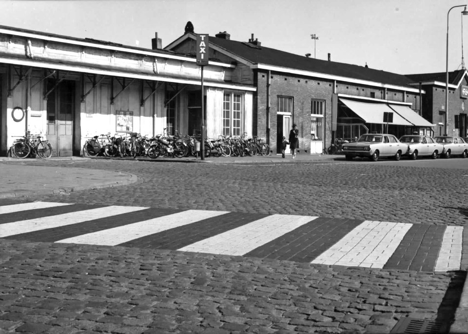 HUA-150193-Afbeelding van een taxistandplaats en fietsenstalling bij het NS station Breda te Breda