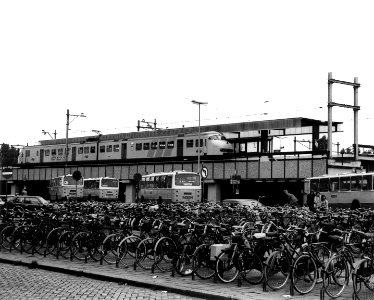HUA-150502-Gezicht op het eerste perron van het N.S.-station Leiden met het electrische treinstel nr. 438 (plan V, mat. 1964) van de N.S. Op de voorgrond een deel van het busstation en de fietsenstalling