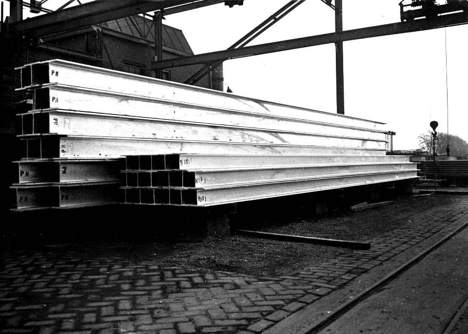 HUA-150494-Afbeelding van een stapel gereedliggende bovenleidingsmasten voor de N.S. op het terrein van de N.V. Plaatverwerkerij en Verzinkerij v.h. P. Bammens & Zn (Straatweg 7) te Maarssen