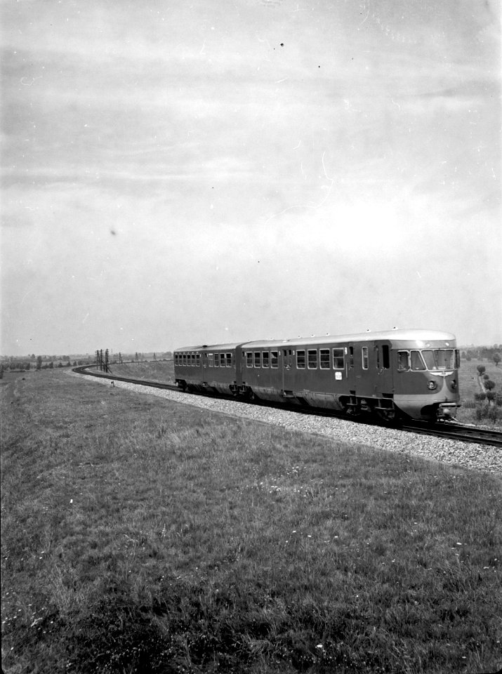 HUA-151347-Afbeelding van een diesel-electrisch treinstel DE 2 (serie 61-106 - Blauwe Engel, vermoedelijk treinstel nr. 61) van de N.S. op de spoordijk ten noorden van de brug over de Beneden Merwede te Baanhoek