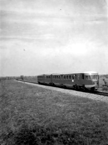HUA-151347-Afbeelding van een diesel-electrisch treinstel DE 2 (serie 61-106 - Blauwe Engel, vermoedelijk treinstel nr. 61) van de N.S. op de spoordijk ten noorden van de brug over de Beneden Merwede te Baanhoek