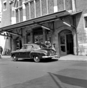 HUA-150364-Afbeelding van een taxi voor de ingang van het N.S-station Haarlem te Haarlem