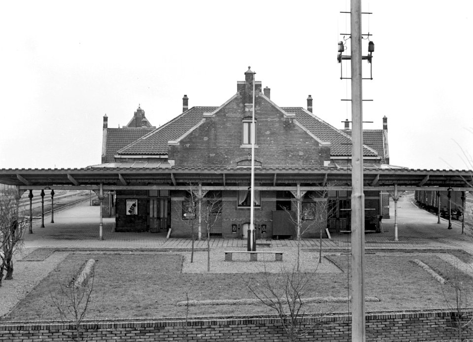 HUA-150472-Gezicht op de zijgevel en de perronkap van het N.S.-station Kesteren te Kesteren, uit het oosten. N.B. Dit gedeelte van het stationsgebouw werd in 1963 door brand verwoest
