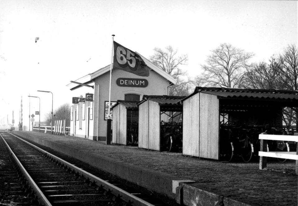 HUA-150226-Gezicht op het N.S.-station te Deinum met fietsenstalling en 65+vlag ten behoeve van de promotie van de zogenaamde 65+ kaart