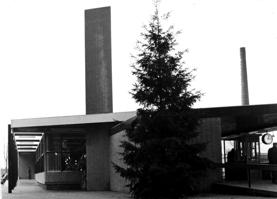HUA-150247-Gezicht op de zijgevel van het N.S.-station Driebergen-Zeist te Driebergen-Rijsenburg, met kerstboom en op het perron de kaartcontrole. Op de achtergrond de fabriekspijp van de Gevato