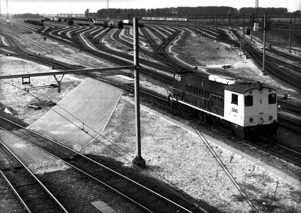HUA-154870-Gezicht op het rangeerterrein Kijfhoek met rechts de radiografisch bestuurbare diesel-electrische locomotief nr. 2260 (serie 2200-2300) van de N.S