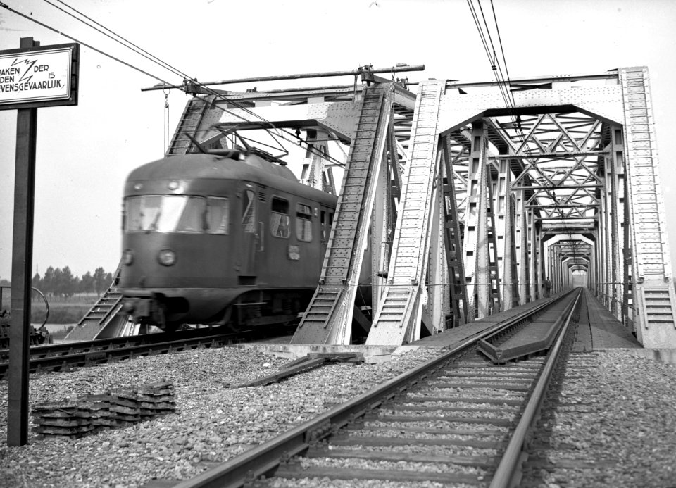 HUA-154939-Gezicht op de spoorbrug over de Maas en een electrisch treinstel mat. 1946 van de N.S. te Buggenum